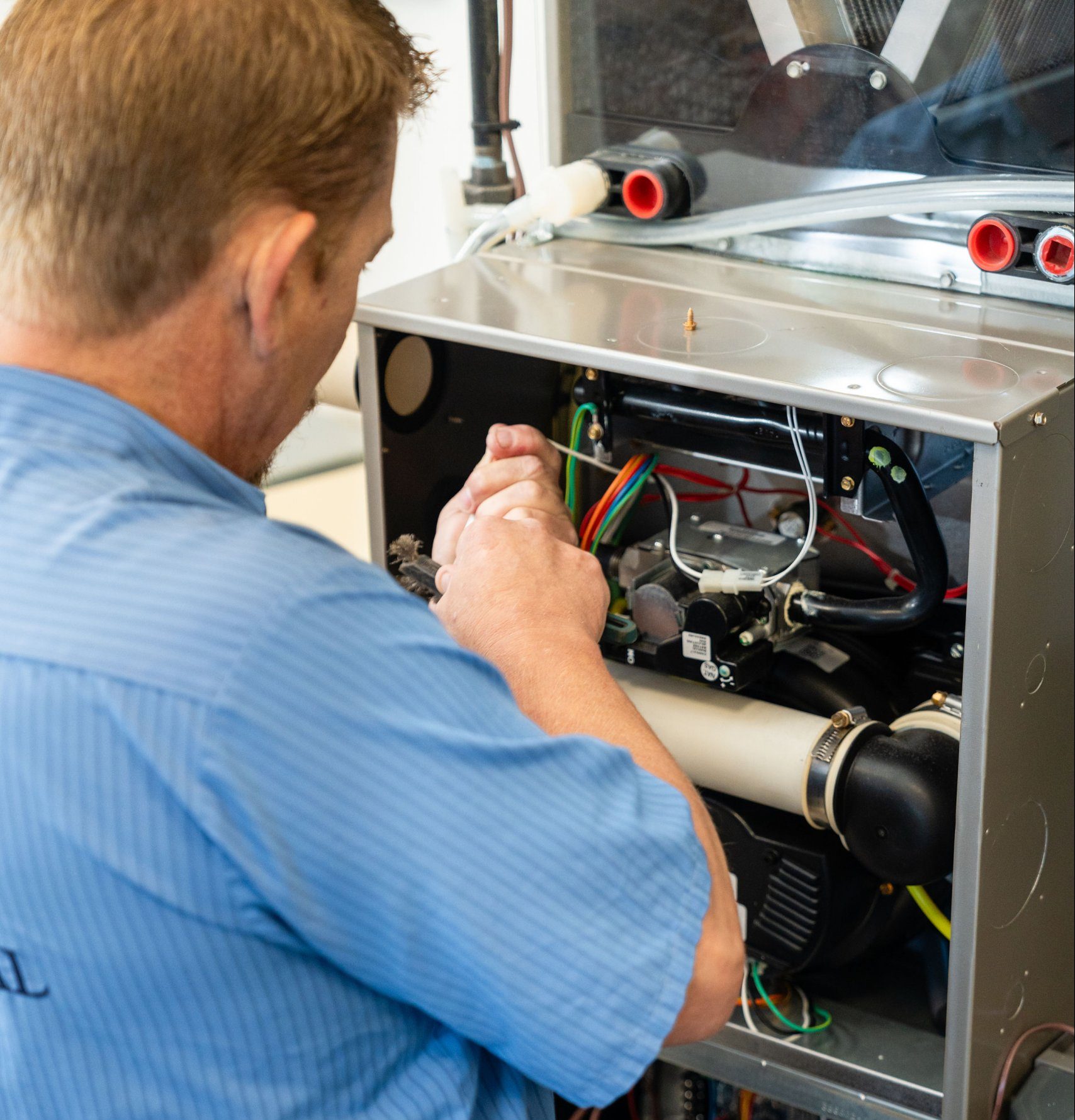 A truck-mounted vacuum unit connected to a Calgary home\'s furnace return, professional duct cleaning setup, garage setting, mid-job atmosphere