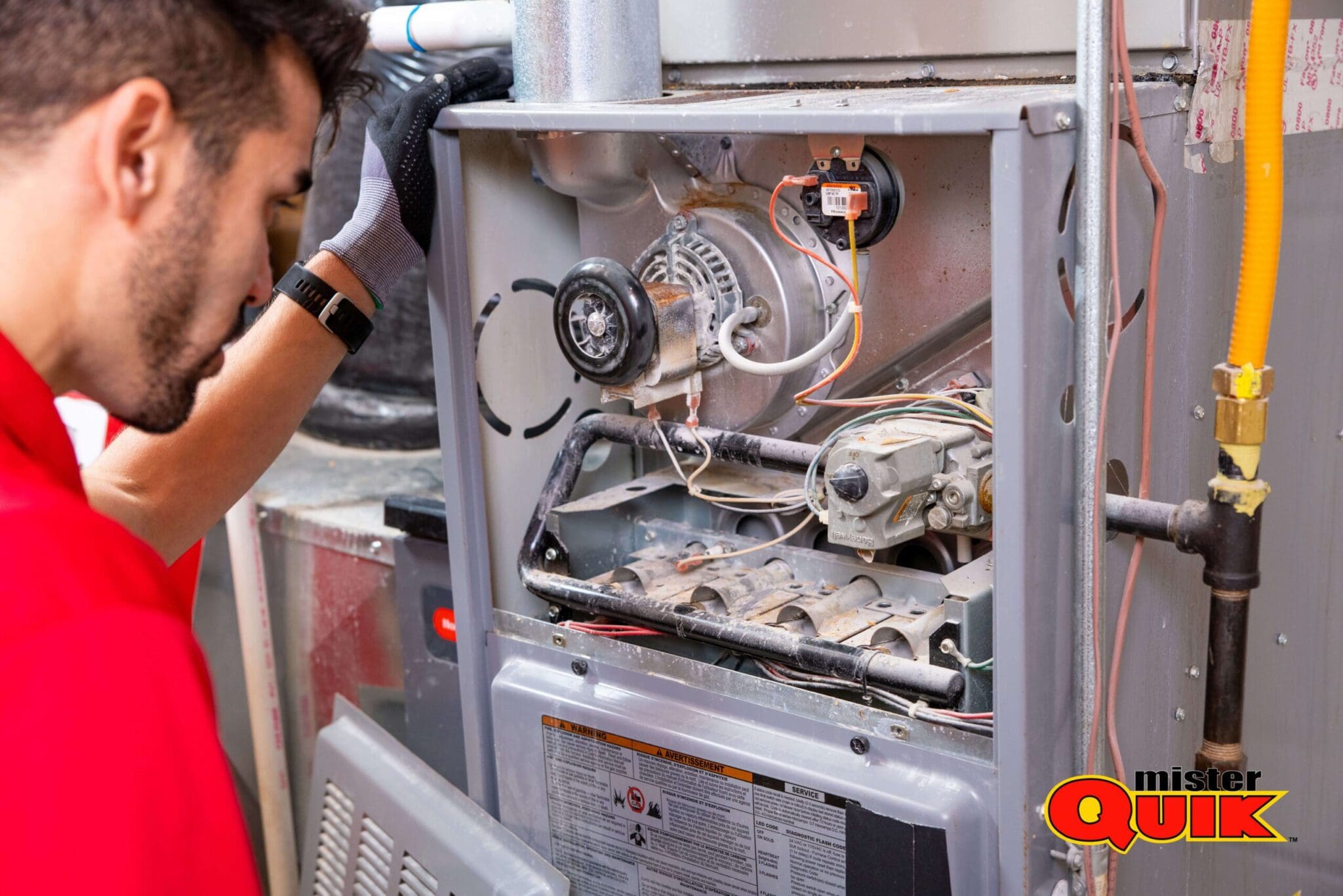 A close-up of a furnace heat exchanger being cleaned with compressed air, Calgary basement setting, technician\'s gloved hand + brush, mid-job atmosphere